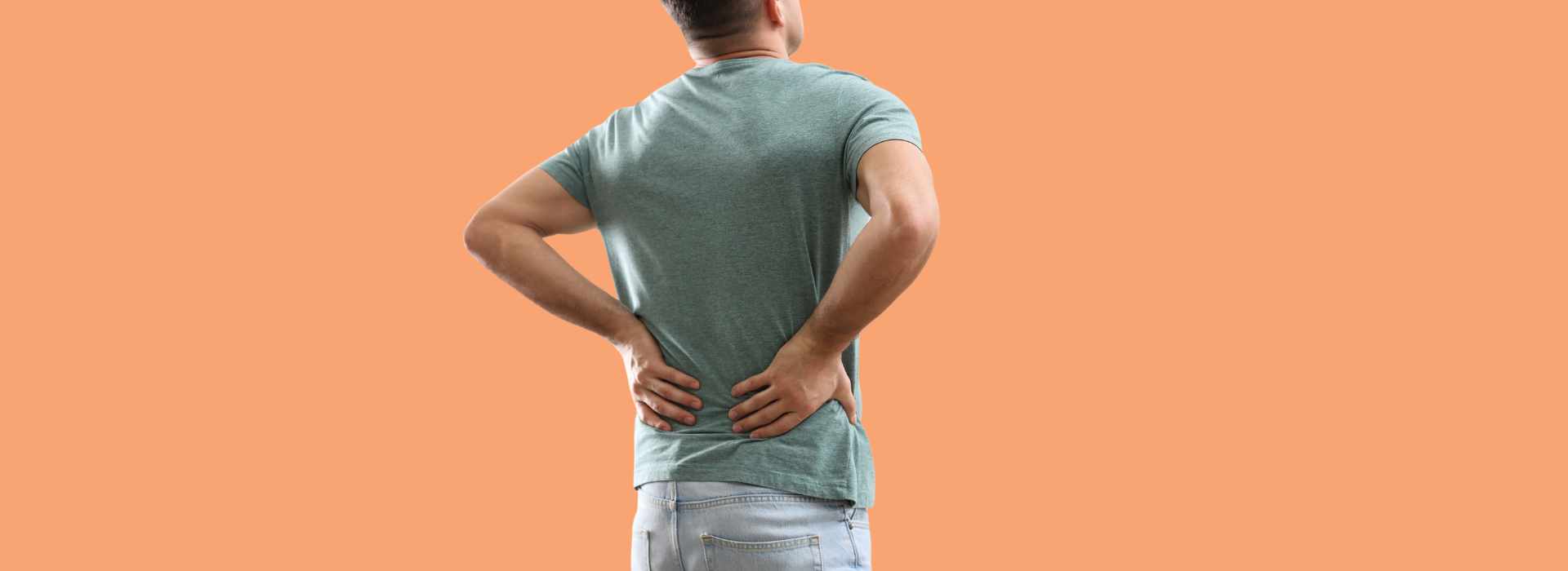 Foto de Capa: Homem de costas põe as mãos na coluna enquanto se alonga por estar com dor