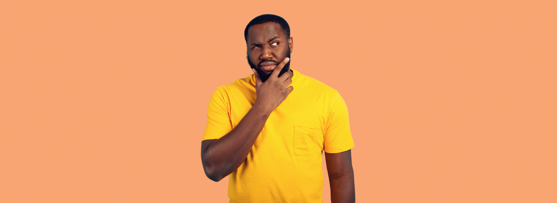 Foto de Capa: Homem curioso com mão no queixo e olhar instigado