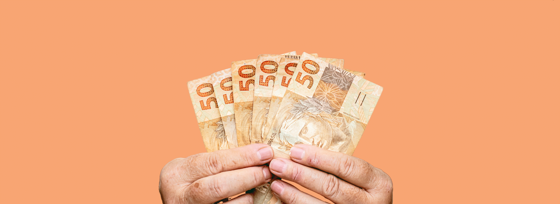 Mãos estendem várias notas de cinquenta reais