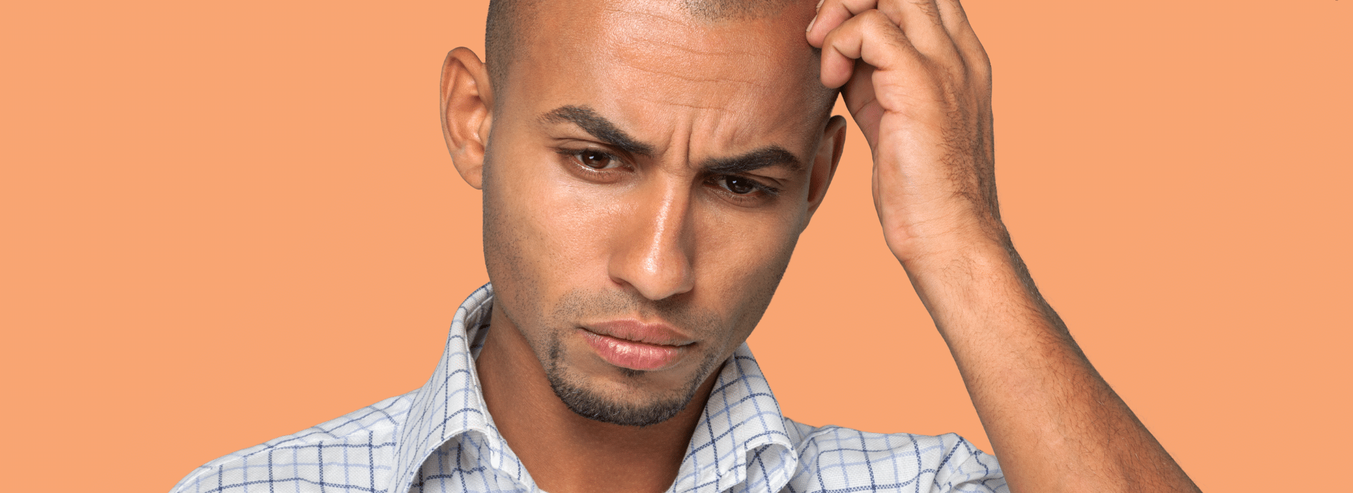 Foto de Capa: Homem coça a cabeça enquanto olha pensativo para baixo