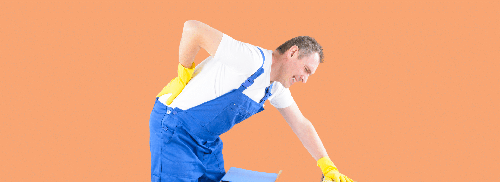 Foto de capa: Faxineiro está abaixado enquanto segura a lombar com dores