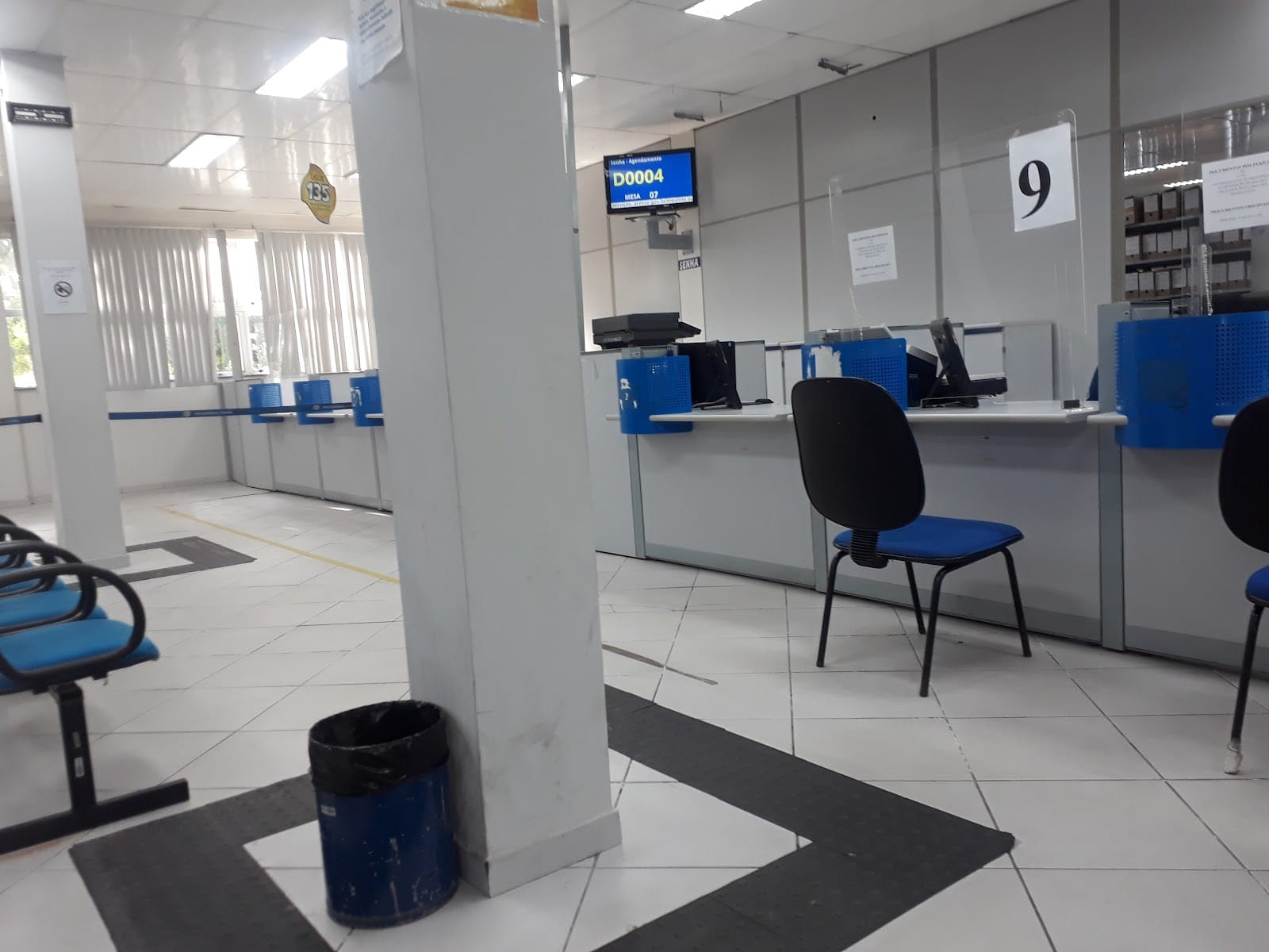 Interior da agência do INSS de Ananindeua com guichês de atendimento e cadeiras azuis