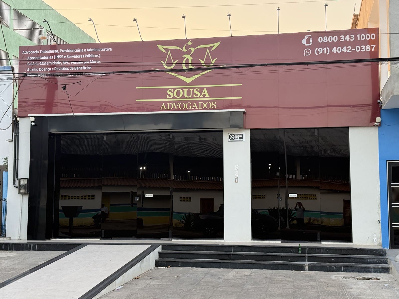 Fachada do escritório Sousa Advogados em Laranjal do Jari, placa marsala com logo e telefones, Av. Independência