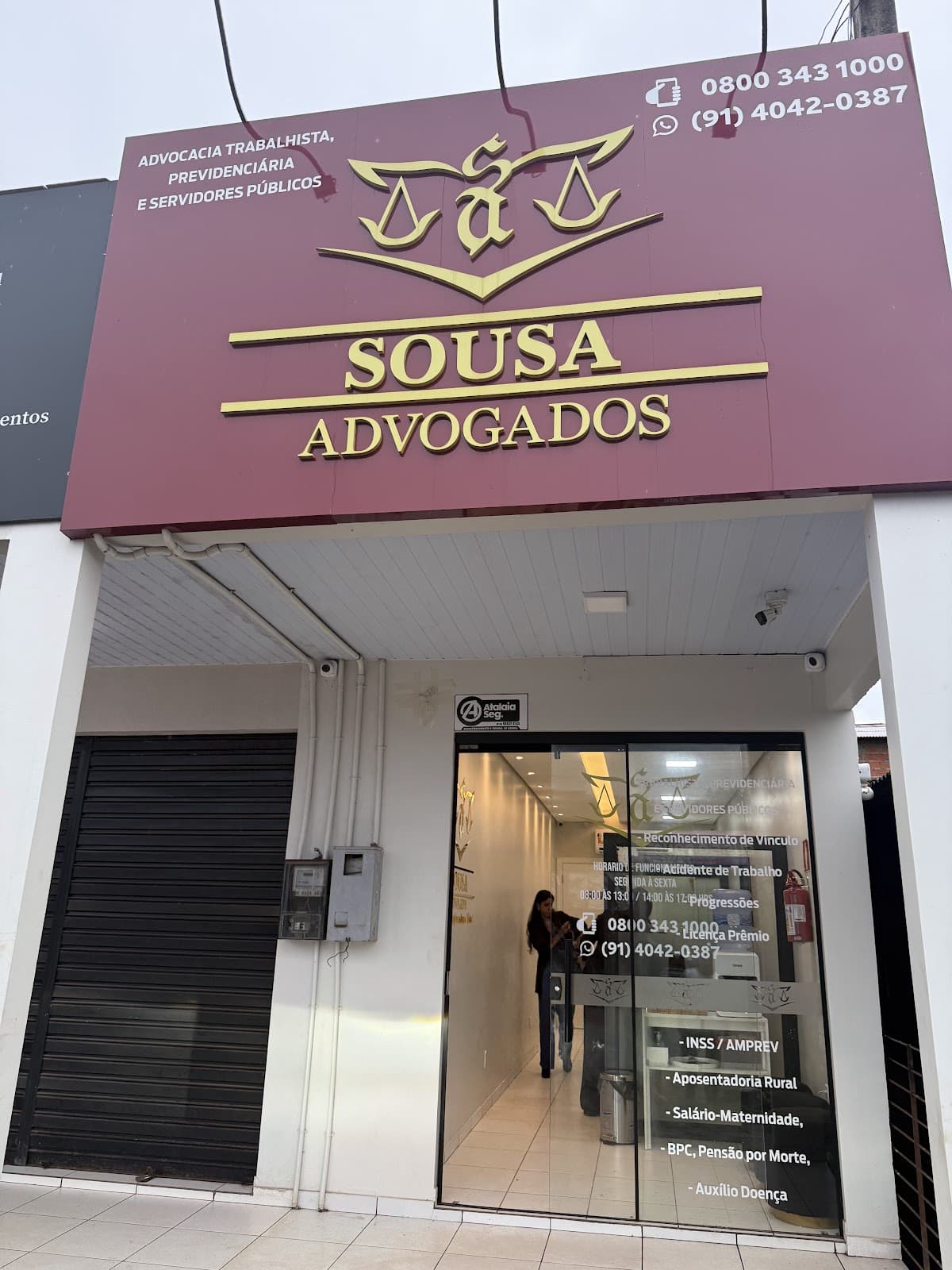 Fachada do escritório Sousa Advogados em Porto Grande, placa marsala com logo e telefones, Rod. Perimetral Norte